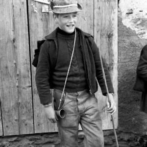 Peter HILTBUNNER, goatherd from Innerferrera, Avers Valley (Grisons, Switzerland) in weatherproof clothing with hat, cane and bugle (brass), 1970.